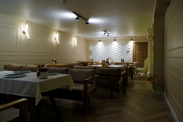 Restaurant interior with tables, sofas, light and honeycomb wall decorative texture background.