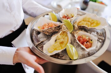 Seafood. Mollusc shellfish. Baked mussels with cheese, cilantro and lemon in oyster shells.