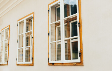 Photo of white and wooden windows in perspective on a white wall