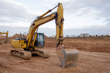 Excavator during earthmoving at construction site. Backhoe dig ground for the construction of...
