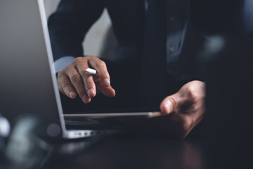 Businessman working on digital tablet and laptop computer in office