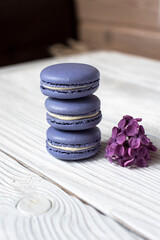 Macaroons  with lilac on a wooden background