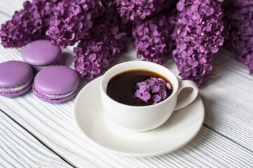 
purple lilac with a cup of coffee and macaroons
