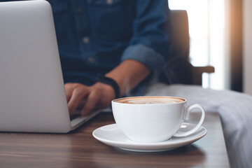 Casual man freelancer online working on laptop computer in coffee shop