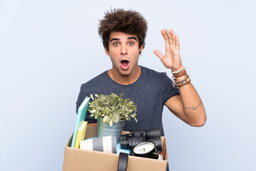 Man making a move while picking up a box full of things with surprise facial expression