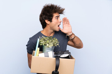 Man making a move while picking up a box full of things shouting with mouth wide open