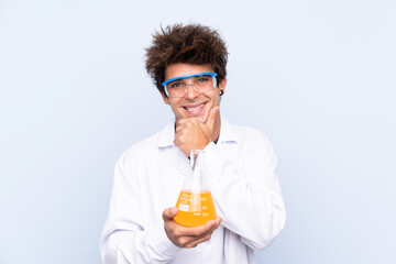 Young scientific man over isolated blue background laughing