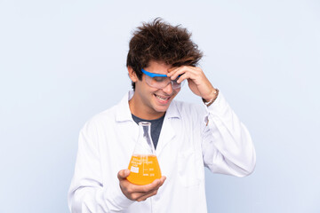 Young scientific man over isolated blue background laughing