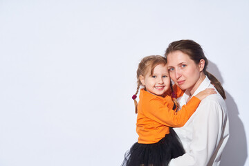 loving mum hugs little girl, holding her tightly in her arms