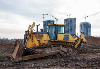 Track-type bulldozer during of large construction jobs at building site. Land clearing, grading, pool excavation, utility trenching, utility trenching and foundation digging. Earth-moving equipment.