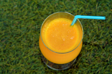 Glass of  fressh orange juice on the grass 