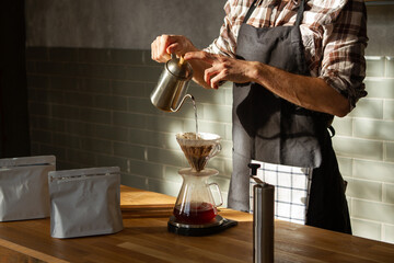 Coffee shop worker standing at the counter with hand drip coffee set