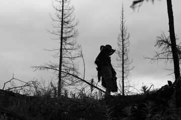 Human silhouette in the dry dead forest, black and white