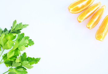 Green parsley and  orange in slices on a white