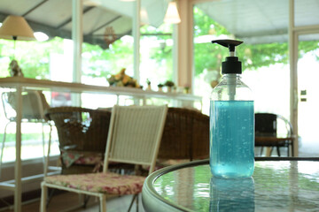 blue alcohol gel in plastic pump bottle for clean hand sanitizer in cafe with prevention coronavirus spread disease