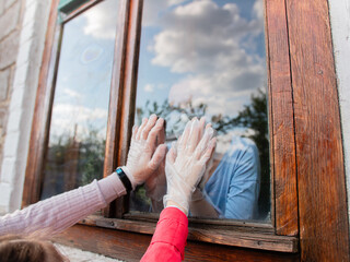 social self-isolation between the family, the hands of a woman and her children touch through the window. Mother and children hoping to meet