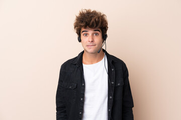 Fototapeta premium Telemarketer man working with a headset over isolated background having doubts and with confuse face expression