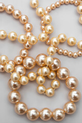 Abstract fashion background with white pearls on the gray background, isolated.