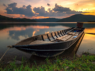 Obraz premium The longtail boat park on the lake at sunset time.