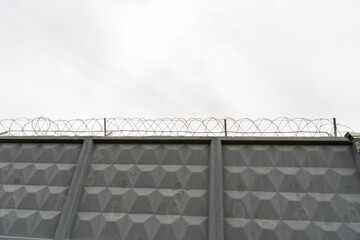 gray concrete wall with barbed wire