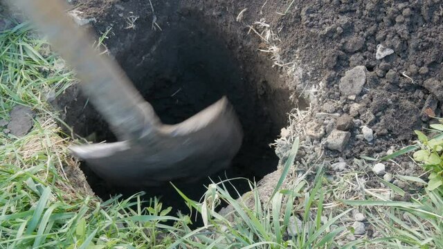 A large vintage old spade digs a hole in the ground.