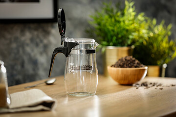 Hot tea on a wooden table in a glass brewer