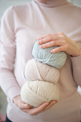 Balls of yarn of different colors in the hands of a girl