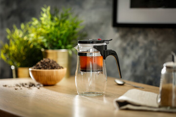 Hot tea on a wooden table in a glass brewer