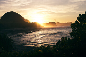 Beautiful sunrise view of a beach in tropical island from the hill top