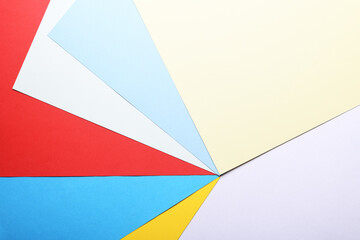 Multicolored paper background. Paper sheets of rainbow colors close-up. Geometric multitask background. Place for text. View from above.Close-up Of Multi Colored Paper.
