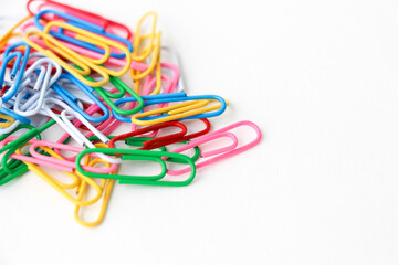 Multicolored paper clips on a white background. Close-up. 