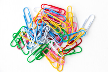 Multicolored paper clips on a white background. Close-up. 