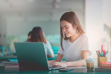 A young woman reading and writtening book with many books, happy education university concept.