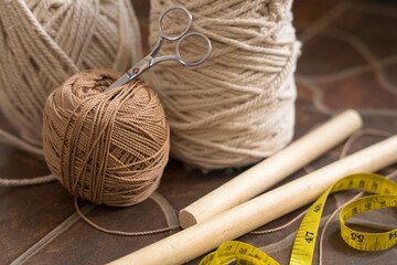 macramé still life - group of cords and threads with scissors and measure tape including wood...