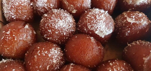 closeup of rusgula gulab jamun with coconut