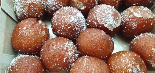 closeup of rusgula gulab jamun with coconut