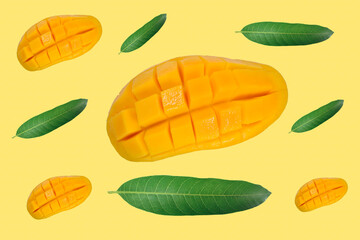 half of Mango fruit decorated with leaves isolated on yellow background close-up, Top view, Flat lay, Creative layout made of mango, Flat lay. Food concept, Fresh yellow ripe mangoes
