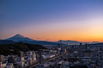 Shizuoka city, Japan, downtown during twilight with Mount Fuji covered with snow in the background...