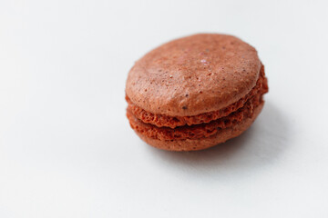 Brown chocolate macaroon cookie isolated on white background. French gluten free dessert