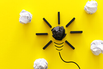 Education concept image. Creative idea and innovation. Crumpled paper as light bulb metaphor over yellow background