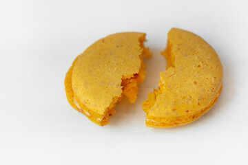 Cracked Yellow lemon macaroon cookie isolated on white background. French gluten free dessert