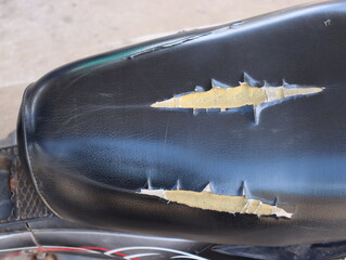 The motorcycle seat is broken and damaged by prolonged use until the sponge inside can be seen