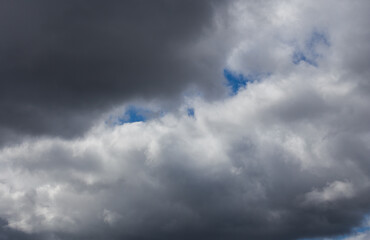 Fluffy clouds cover the summer blue sky