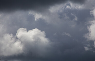 Fluffy clouds cover the summer blue sky