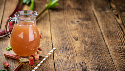 Rhubarb Juice on rustic background (close up; selective focus)