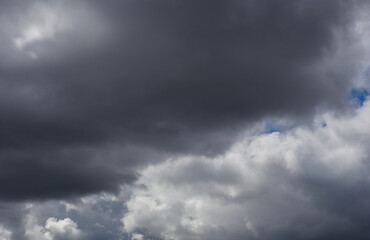 Fluffy clouds cover the summer blue sky