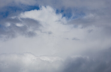 Fluffy clouds cover the summer blue sky