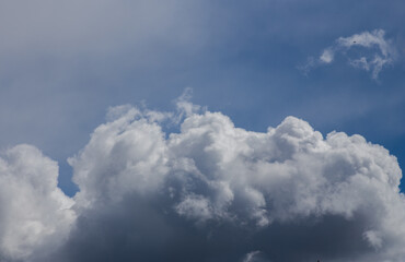 Fluffy clouds cover the summer blue sky