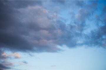 Fluffy clouds cover the summer blue sky