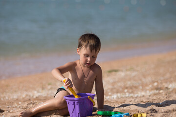 boy playing on the beach with his toys